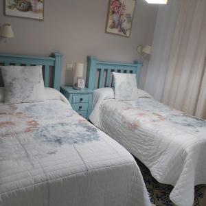 卡索拉Vivienda Rural Rio Cerezuelo的一间带两张床和蓝色梳妆台的卧室