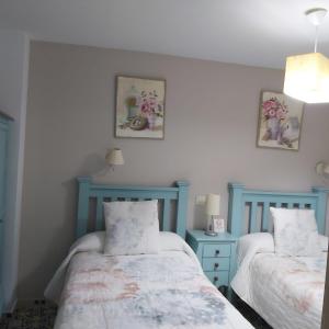 卡索拉Vivienda Rural Rio Cerezuelo的蓝色和白色的客房内的两张床