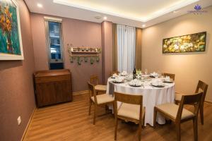 海阳Purple Lotus Hotel的一间配备有白色桌椅的用餐室
