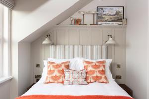 阿尔恩茅斯The Whittling House的一间卧室配有带橙色和白色枕头的床