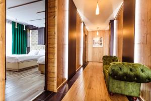 诺瓦齐- 斯特拉尼L’INVIDIA的酒店客房,配有一张床和一把绿色椅子