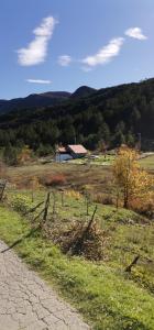 特雷比涅Trebinje - Lastva - Vikendica Vukovic-的围栏,在田野上,有谷仓的背景