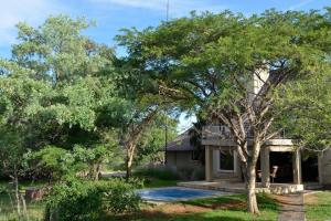 马布拉Zebula Golf Estate and Spa - Private Rentals的一座带游泳池和树木的房子