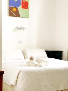 马德普拉塔阿尔蒂科酒店的一张白色的床,上面有一堆毛巾
