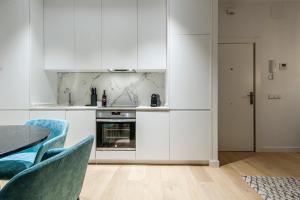 马德里Hauzify I Apartamento Salamanca的厨房配有白色橱柜和桌椅