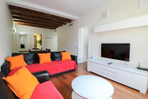 巴塞罗那赫罗纳108酒店的客厅配有红色沙发和平面电视