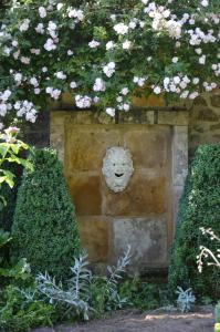 Bois-Sainte-MarieMaison d'hôtes - Les Tillets的花卉面孔的石墙
