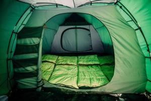 阿姆斯特丹The ESN Kingsday Campsite的绿色和白色的帐篷,配有一张床