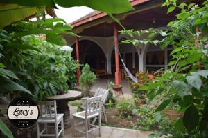 格拉纳达Casa Lucys Hostal的房屋前设有带桌椅的花园