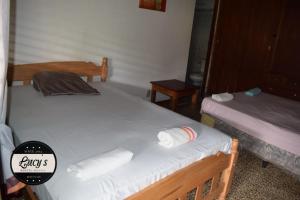 格拉纳达Casa Lucys Hostal的客房内的两张床和毛巾