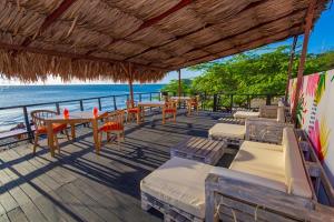 圣玛尔塔GIO Hotel Tama Santa Marta的海滩上的餐厅,配有桌椅