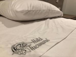 IníridaHotel Tucunaré的带有枕头的床,带有非自愿的汉字
