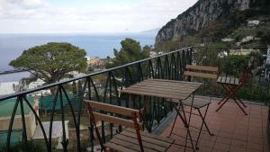 卡普里拉玛克塞拉度假屋的俯瞰大海的阳台配有桌椅