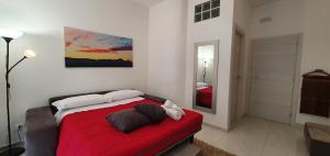 佩斯卡拉La Dimora di Maja的卧室配有红色的床,墙上挂有绘画作品