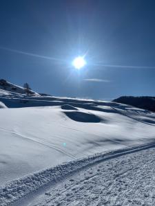 瓦尔Appartement Vars Sainte Marie 6 personnes的一片雪覆盖的田野,背着太阳