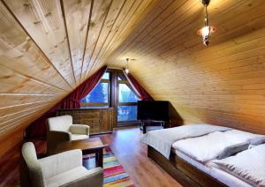 什特尔布斯凯普莱索High Tatras Chalet的卧室设有木制天花板、一张床和电视。