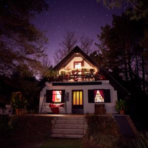 贝拉茨尔克瓦Ladybird Lodge的屋顶上晚上有圣诞灯的房子