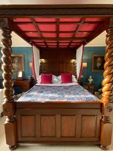 LonghopeBlaisdon House B&B的一间卧室配有一张带红色枕头的大床