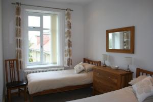 尚克林Shanklin Manor的一间卧室设有两张床和窗户。