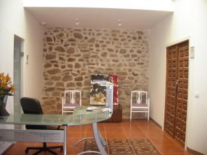 AniñonHostel El Castillo的一间设有石墙和玻璃桌的房间