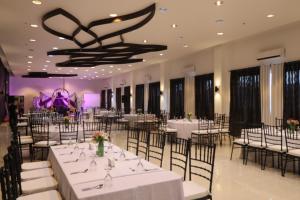 大雅台泰克宜景观花园酒店的宴会厅配有白色的桌椅和吊灯