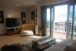 Ban Na DanKhanom Beach Residence Sea & Mountain View - 1 Bedroom的带沙发和电视的客厅以及阳台。