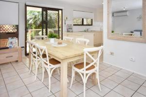 穆卢拉巴20 Steps to the Sand!的厨房以及带木桌和椅子的用餐室。