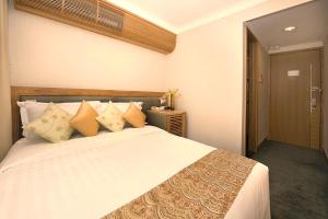 香港宏基国际宾馆的卧室配有带枕头的大型白色床