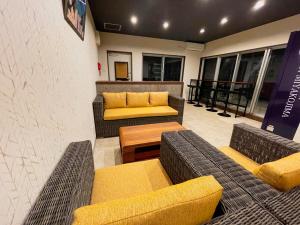 宫古岛HOTEL Fit in Miyakojima的大楼内带沙发和桌子的等候区