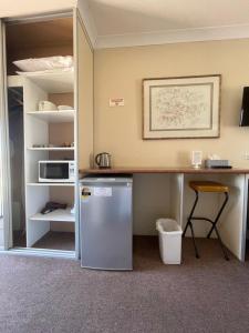 昆比恩马古丽塔汽车旅馆的带冰箱的厨房以及带微波炉的书桌。