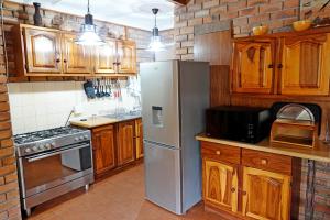 玛洛斯帕克Tau @ Kruger的厨房配有木制橱柜和不锈钢冰箱。