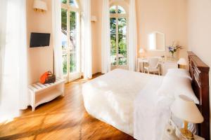 圣雷莫西尔瓦别墅Spa酒店的卧室配有一张白色大床和一张书桌