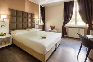 圣雷莫西尔瓦别墅Spa酒店的卧室配有一张白色大床和一张书桌