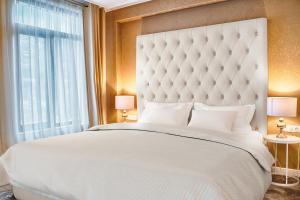 大特尔诺沃Tsarevets Design and Spa的卧室设有一张白色大床和一扇窗户。