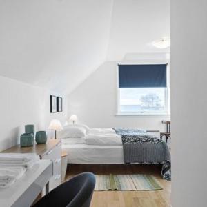 ØlstedStrandsegård Ferielejlighed的白色的卧室设有床和窗户