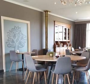 比亨豪特Hotel B - Boskapelhoeve的一间带桌椅的用餐室和一幅画