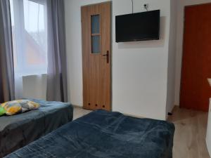米耶伦科Villa Monica pokoje dwuosobowe tylko dla dorosłych的客房设有两张床和一台平面电视。