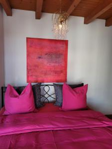 卢塞恩Villa Castagna Guesthouse的卧室配有粉红色枕头,墙上挂有绘画作品