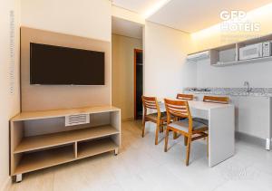 萨利诺波利斯SALINAS PARK - GAV Resorts的一间带桌椅和电视的用餐室