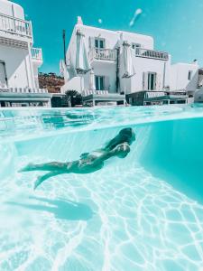 圣斯特凡诺斯Mykonos Princess Hotel的海豚在房子前的游泳池游泳