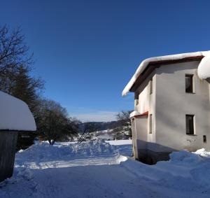 捷克布杰约维采U Kapličky的一座被雪覆盖的建筑,位于院子旁边