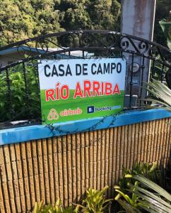 阿雷西博Casa de Campo Rio Arriba的木栅栏顶部的标志