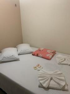 瓜拉米兰加Apartamento Central的一张带两个枕头的白色床和毛巾