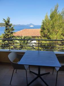 大洛希尼Apartmaji Punta的海景阳台上的蓝色桌子
