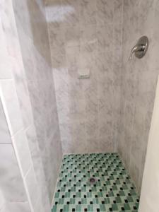 劳德代尔堡皇冠旅馆的浴室铺有黑白地板,设有淋浴。