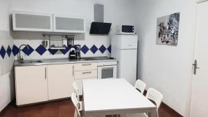 弗龙特拉Casita con Barbacoa的白色的厨房配有桌子和白色冰箱