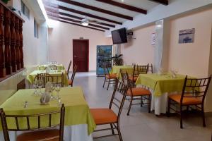 埃斯梅拉达斯Hotel Cayapas Esmeraldas的餐厅设有桌椅和黄色桌布