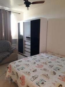 坎普斯戈伊塔卡济斯Apartamento Orquídea的一间卧室配有一张床和一个橱柜