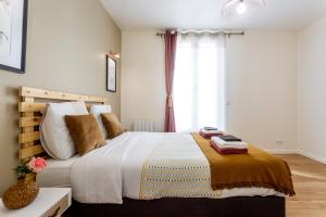 圣旺StayLib - Lovely 2 rooms porte de Montmartre的一间卧室设有一张大床和一个窗户。
