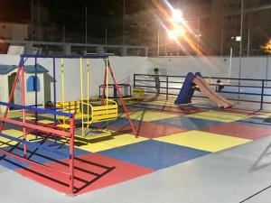 瓜鲁雅Apartamento Praia Enseada的游戏室,带滑梯的游乐场